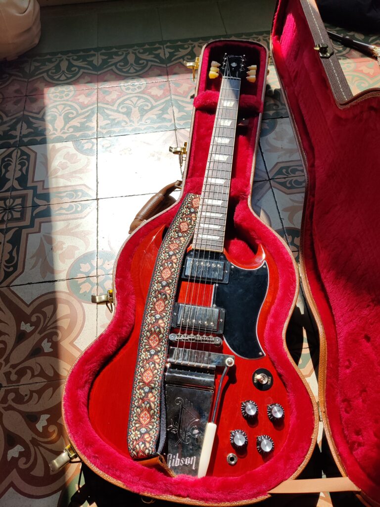 Gibson SG in its original hardshell case (the strap is not the one included with the guitar)